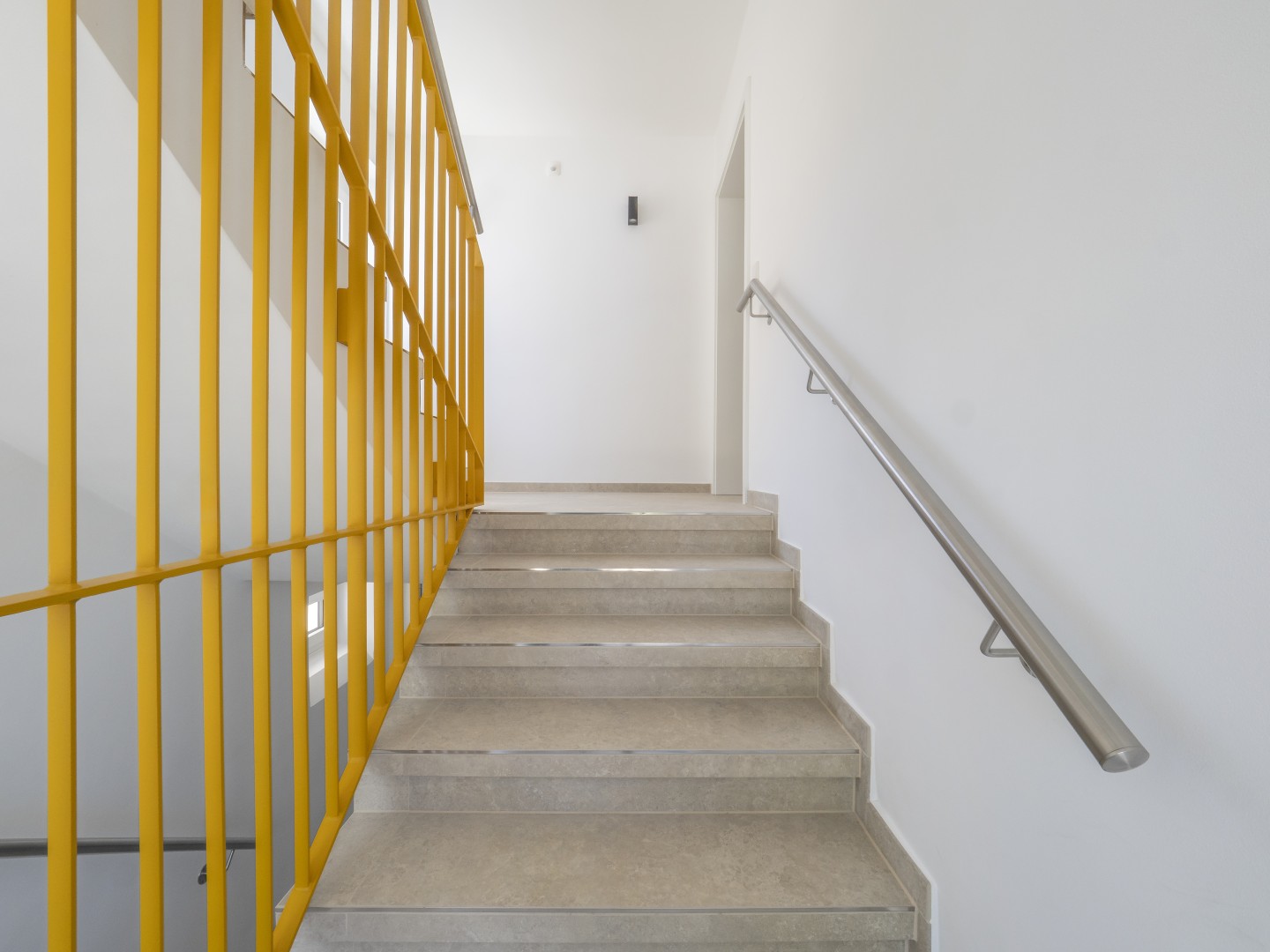 Neues Treppenhaus mit gelbem Gel&auml;nder